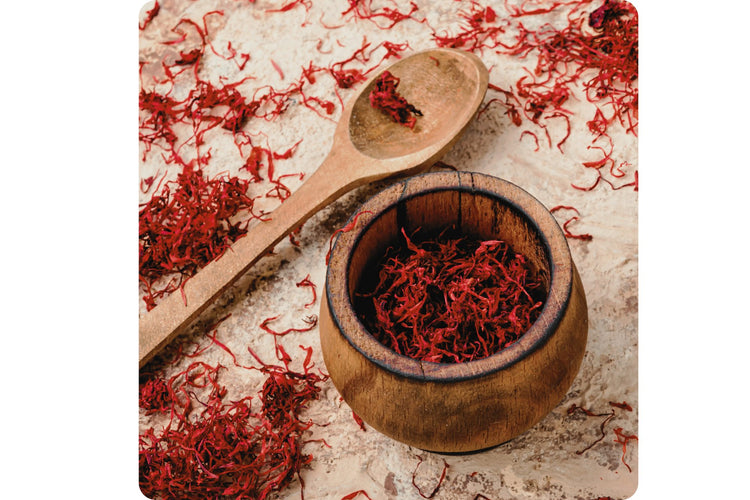 Vibrant red saffron threads freshly harvested, laid out with a wooden spoon, showcasing the delicate and prized part of the saffron crocus flower.