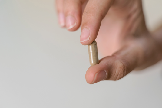 JUNOVU HAND SHOWING A SAFFRON CAPSULE IMAGE 